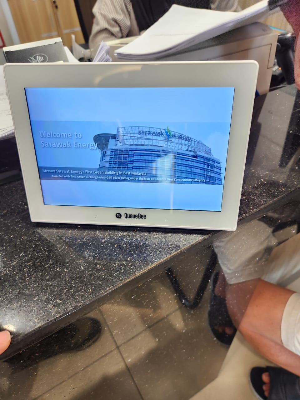 Queue management display installed at a service counter for customer flow control